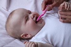 Baby, der får børstet tænder.