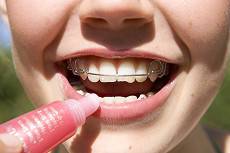 Pige med bøje smiler og putter lipgloss på.